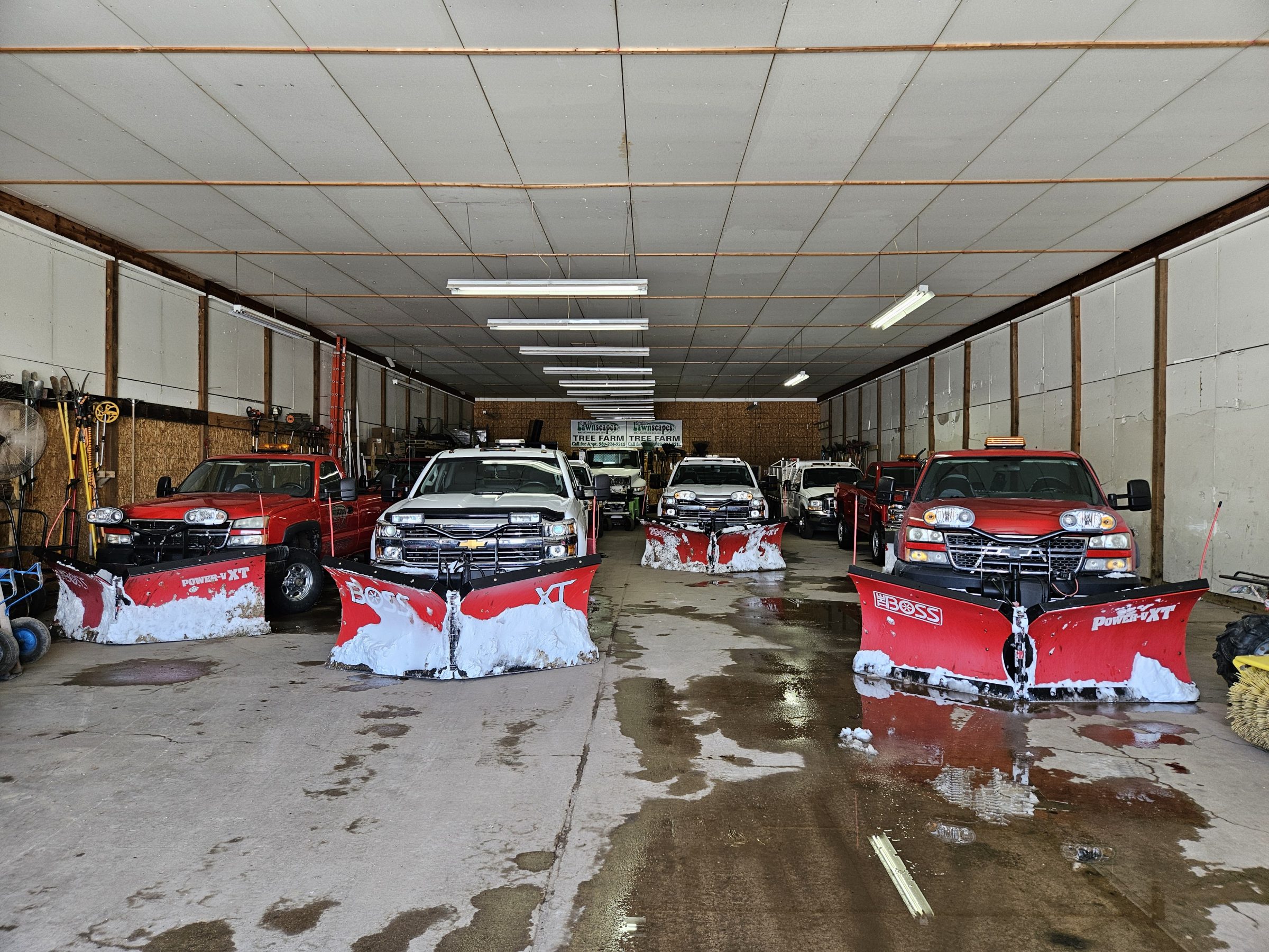 Snow plow trucks parked in a garage