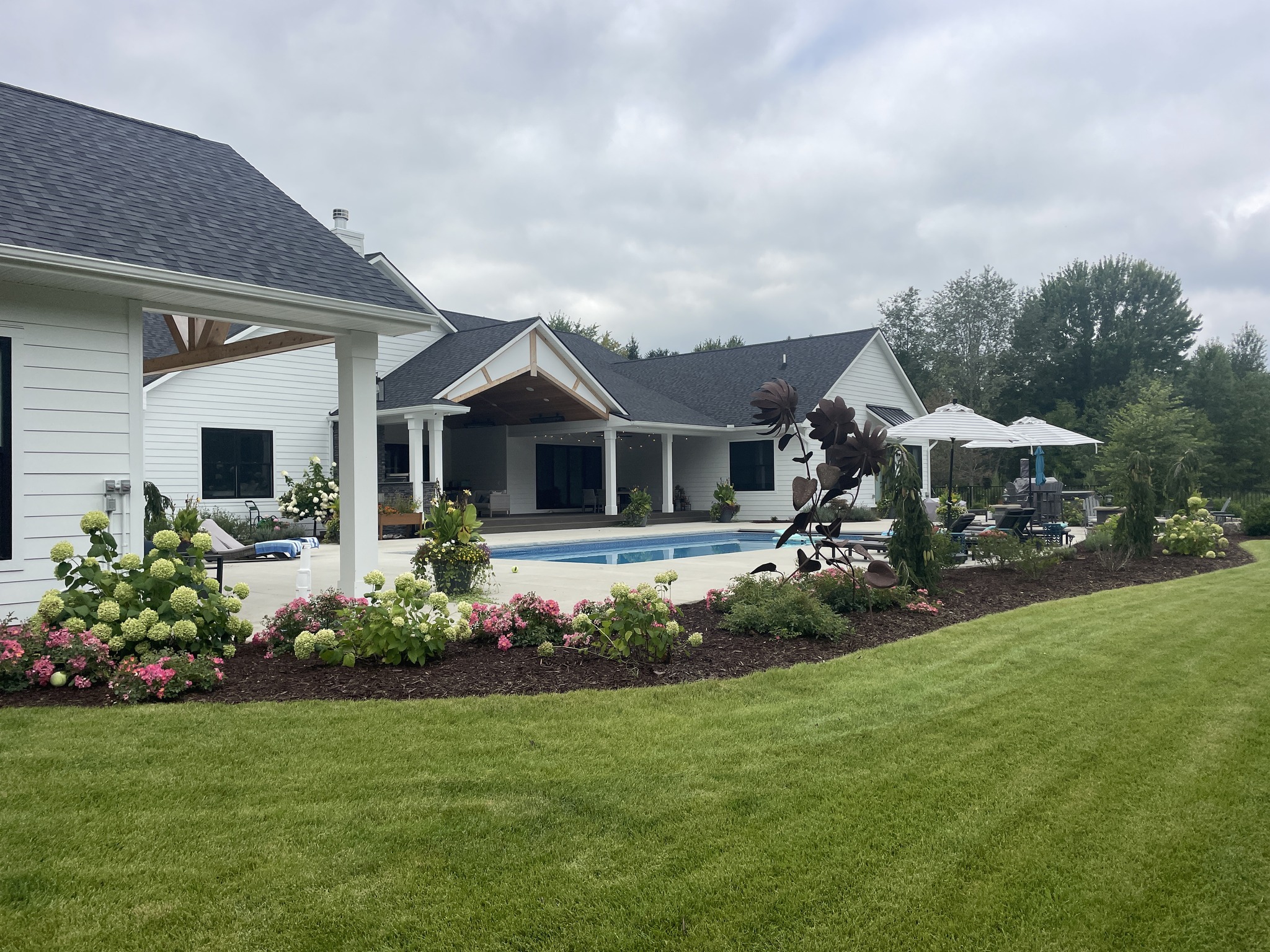 Backyard garden with pool and patio view.