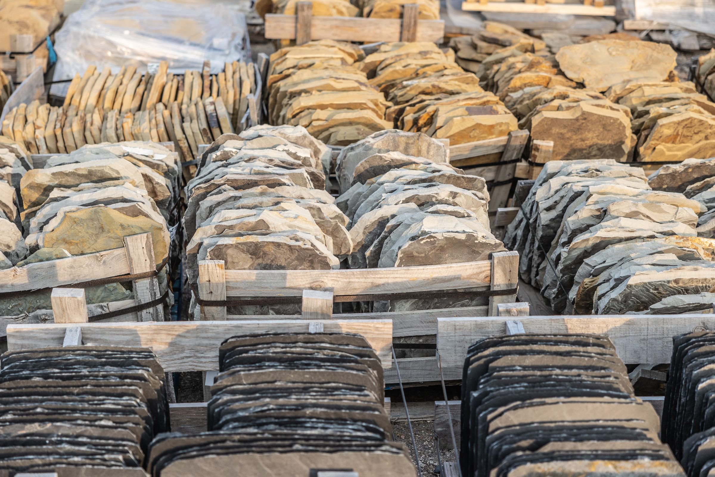Stacks of natural stone slabs on pallets.