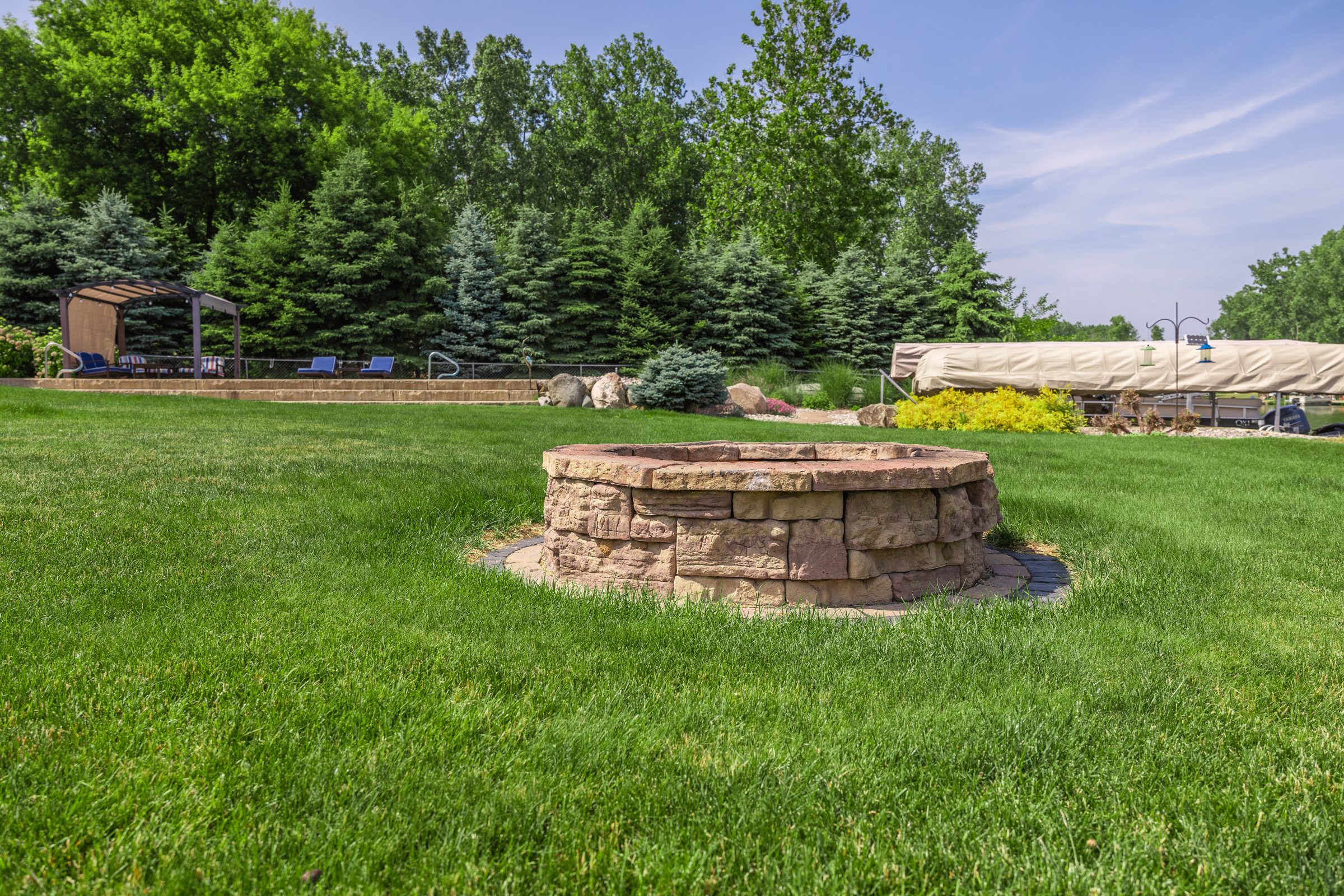 Backyard with stone fire pit and trees.