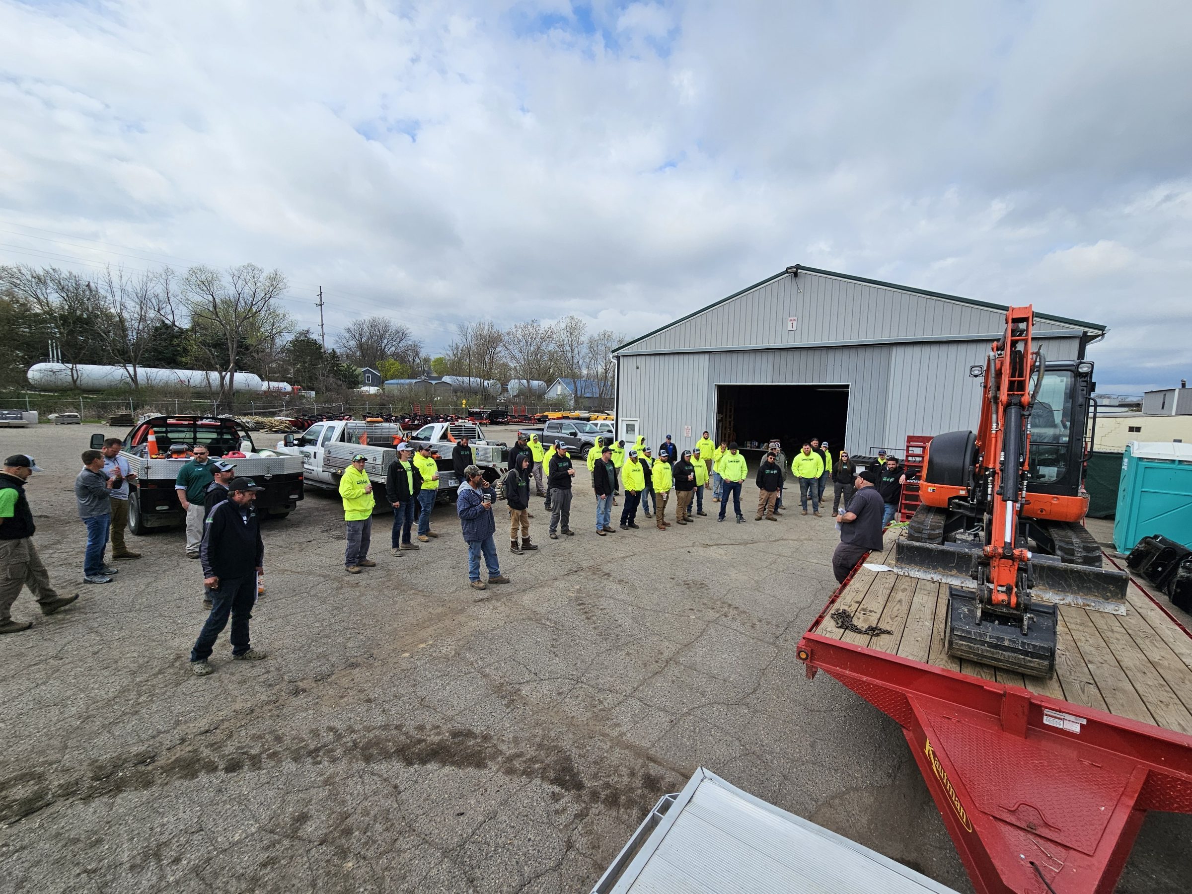Group gathered for outdoor construction equipment demonstration.