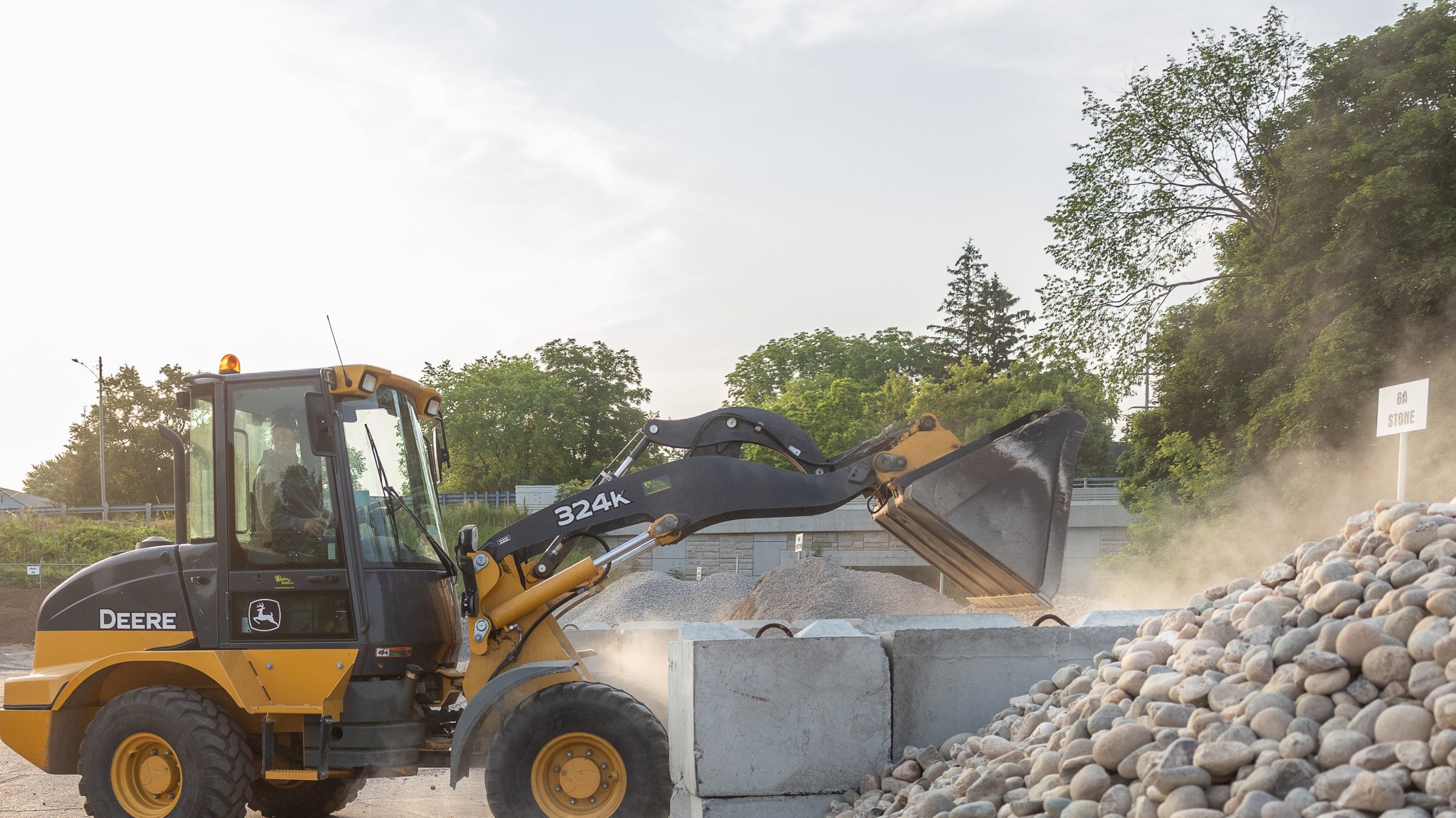Loader moving large rocks at construction site