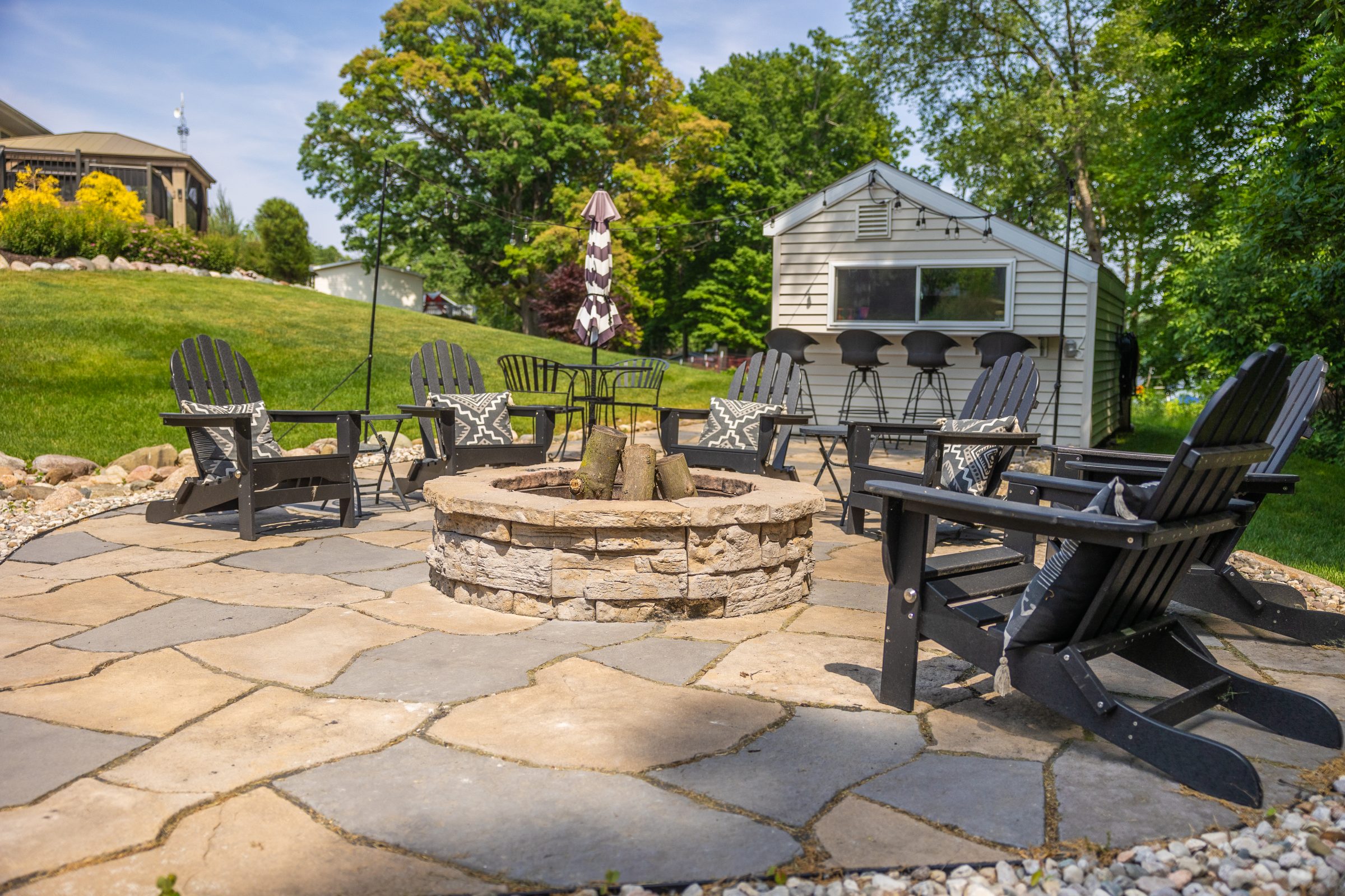 Outdoor patio with fire pit and chairs.