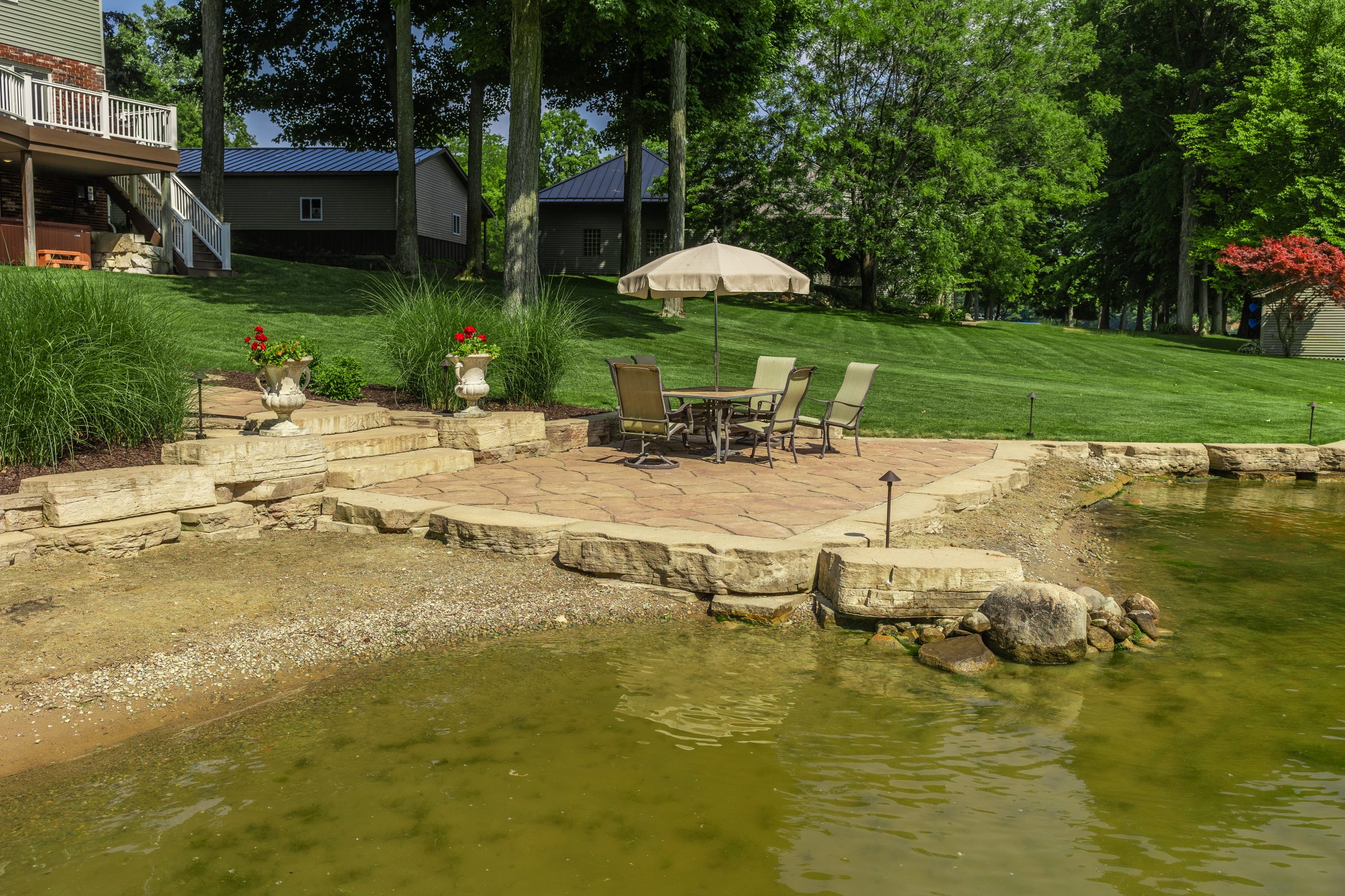 Backyard patio overlooking pond and lush lawn