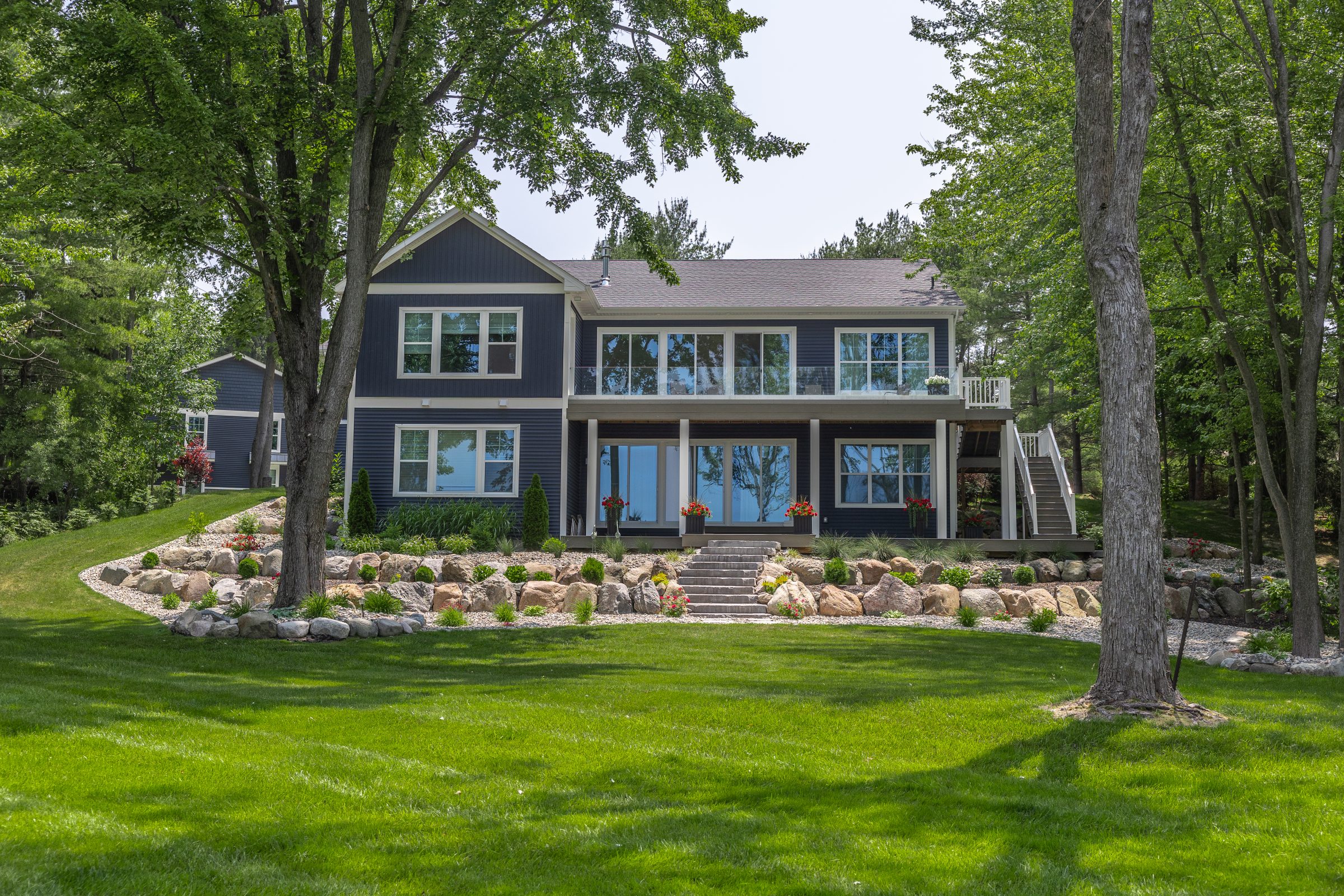 Modern house with large windows and landscaped yard.