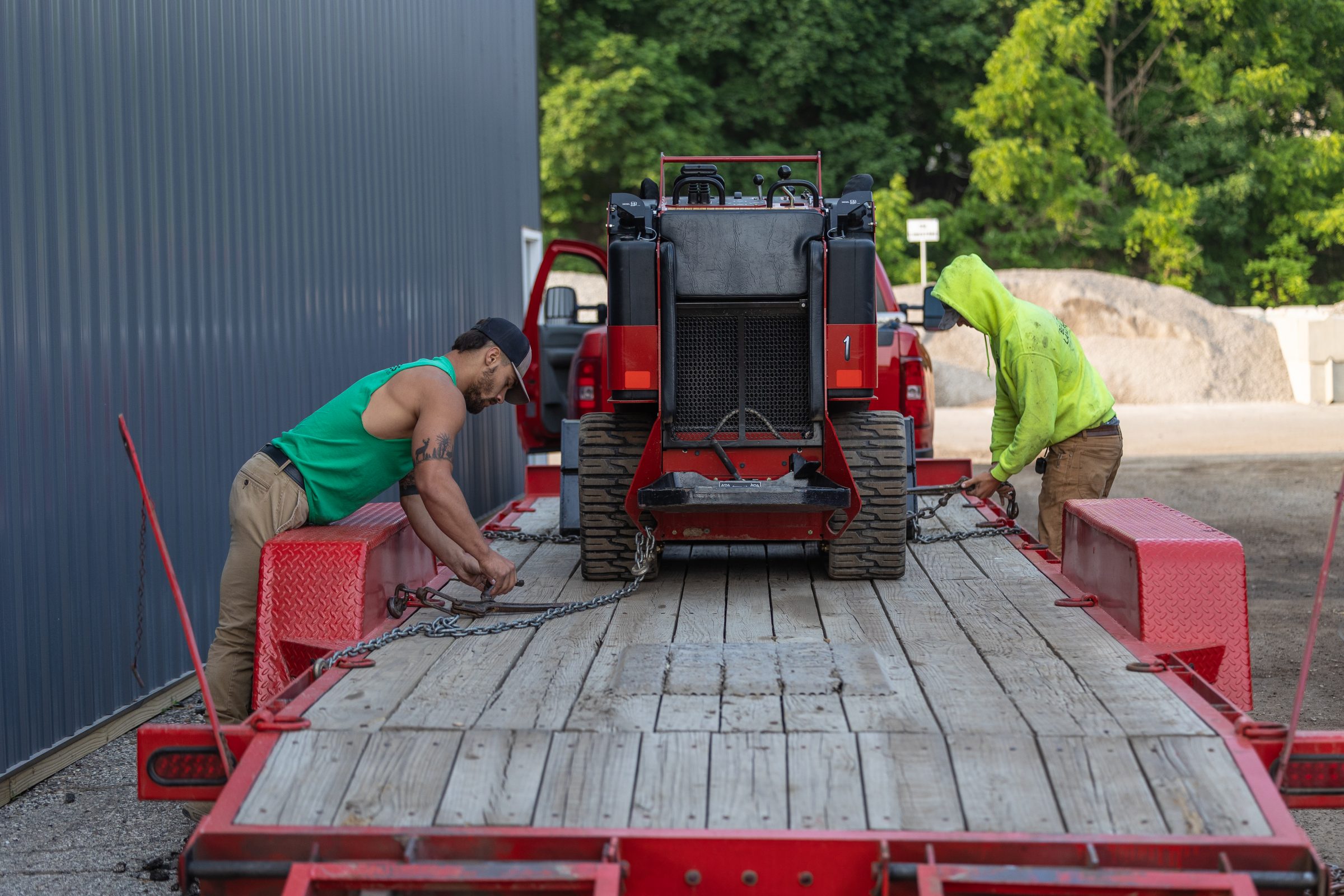 Workers securing equipment on a trailer