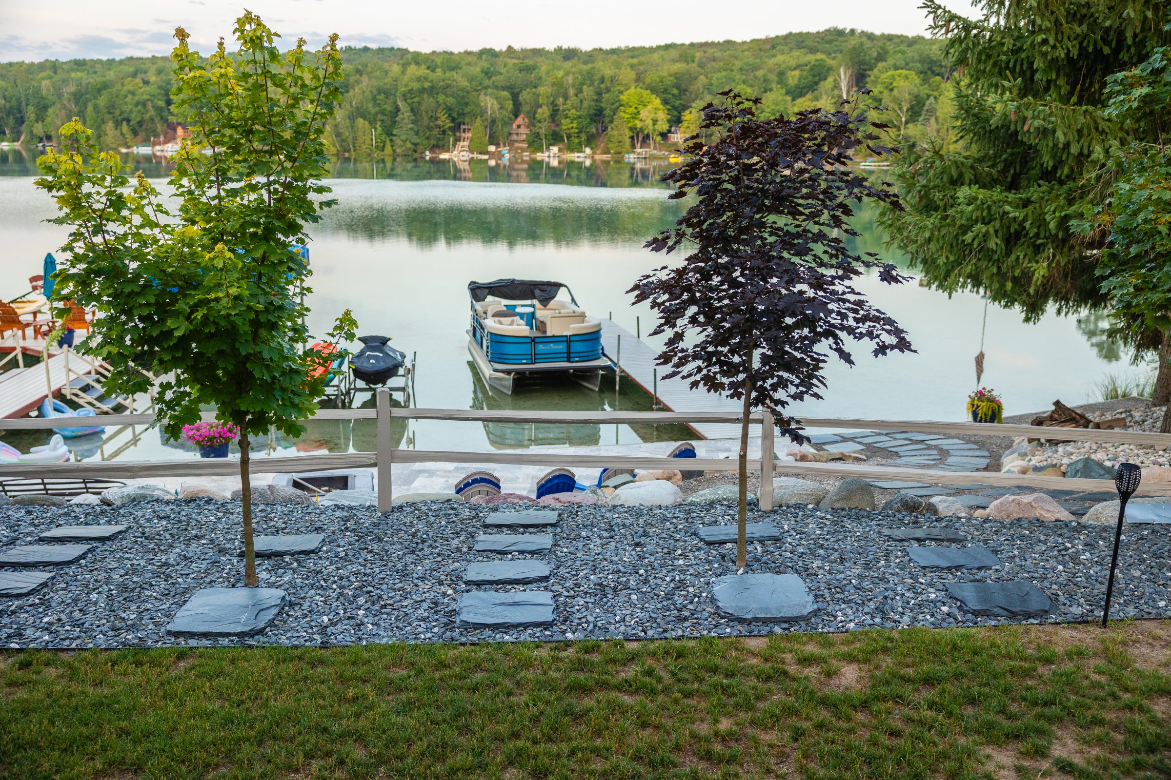 Lakeside view with dock and pontoon boat.