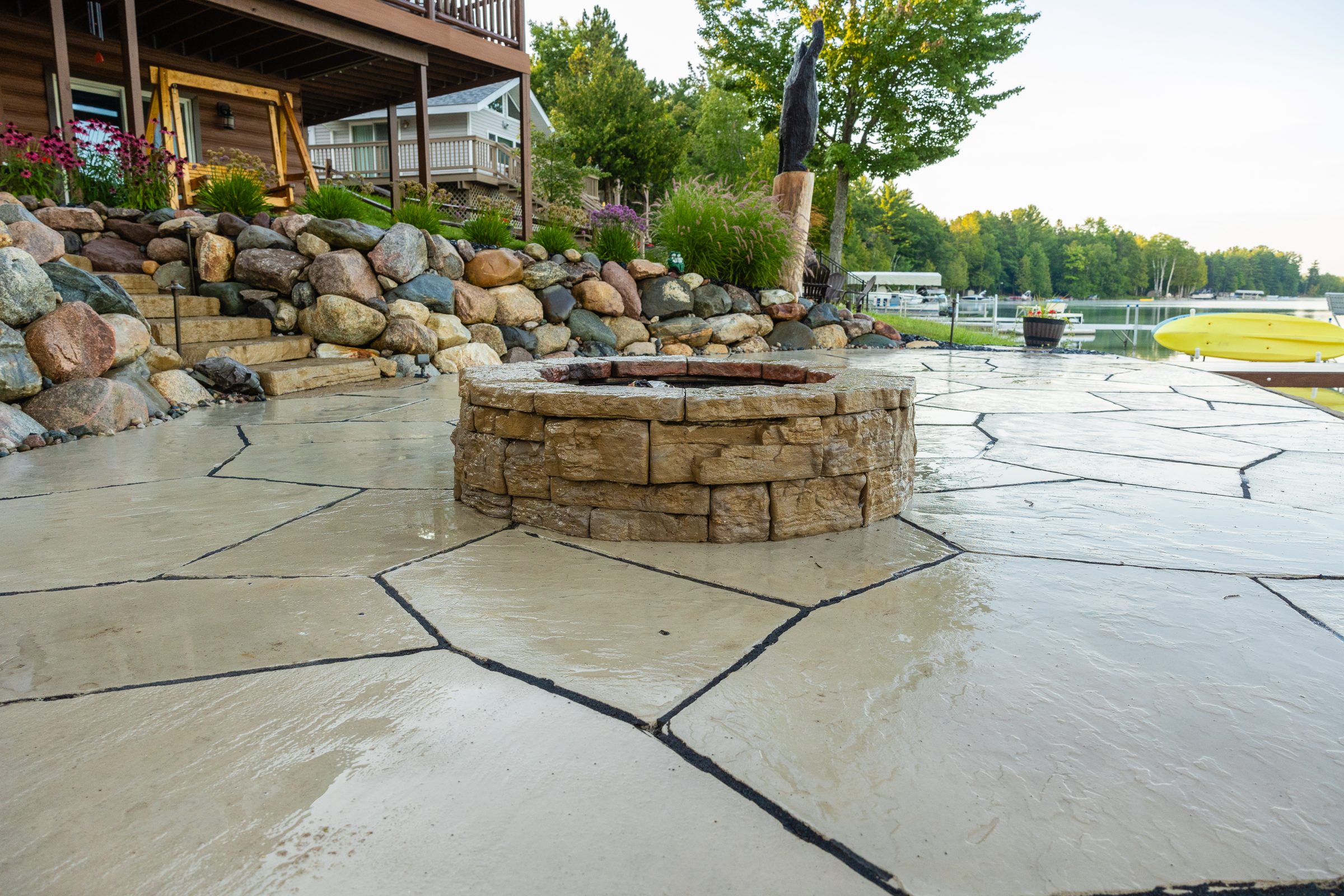 Stone patio with fire pit and lake view