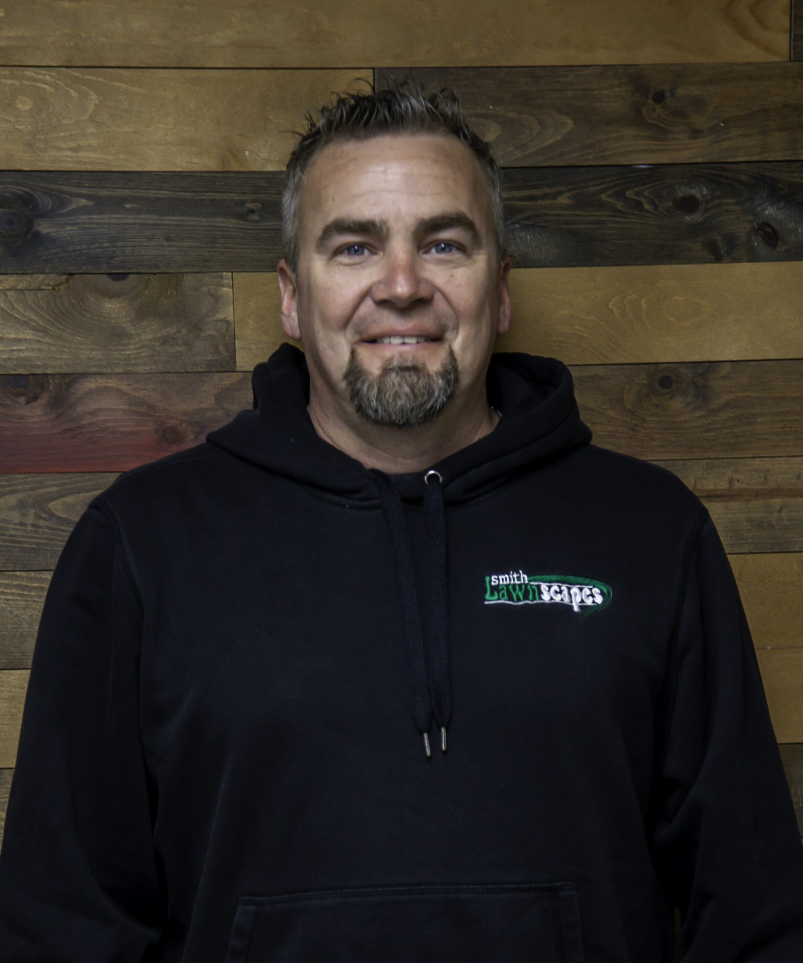 Man in black hoodie, wooden background