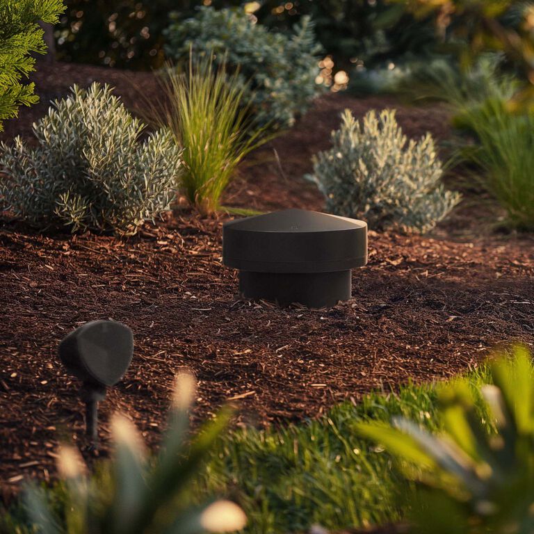 Outdoor speaker in landscaped garden setting