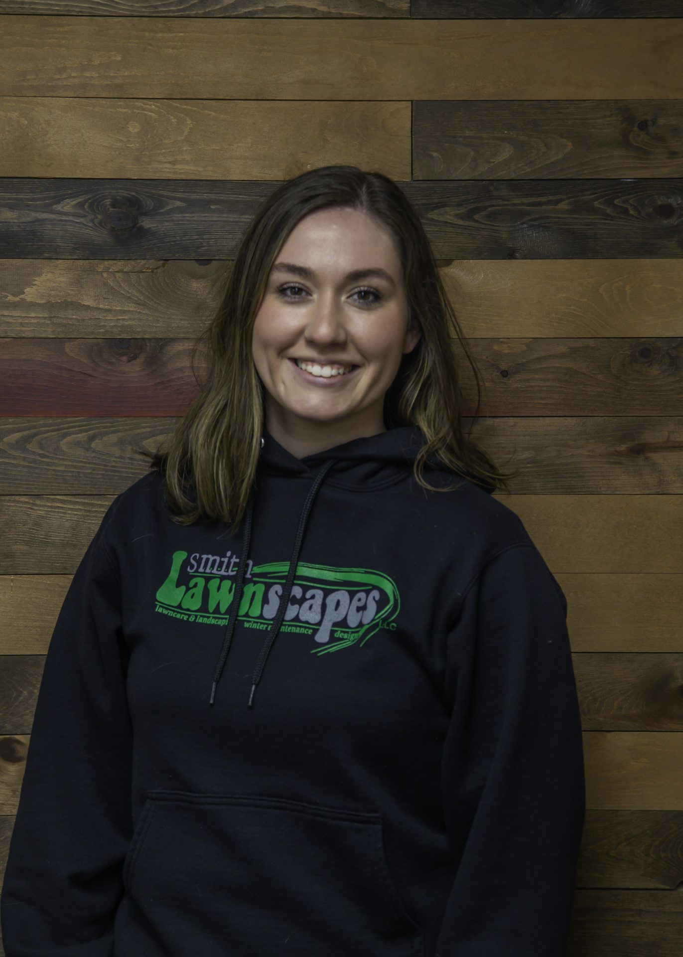 Smiling person in Smith Lawnscapes hoodie.