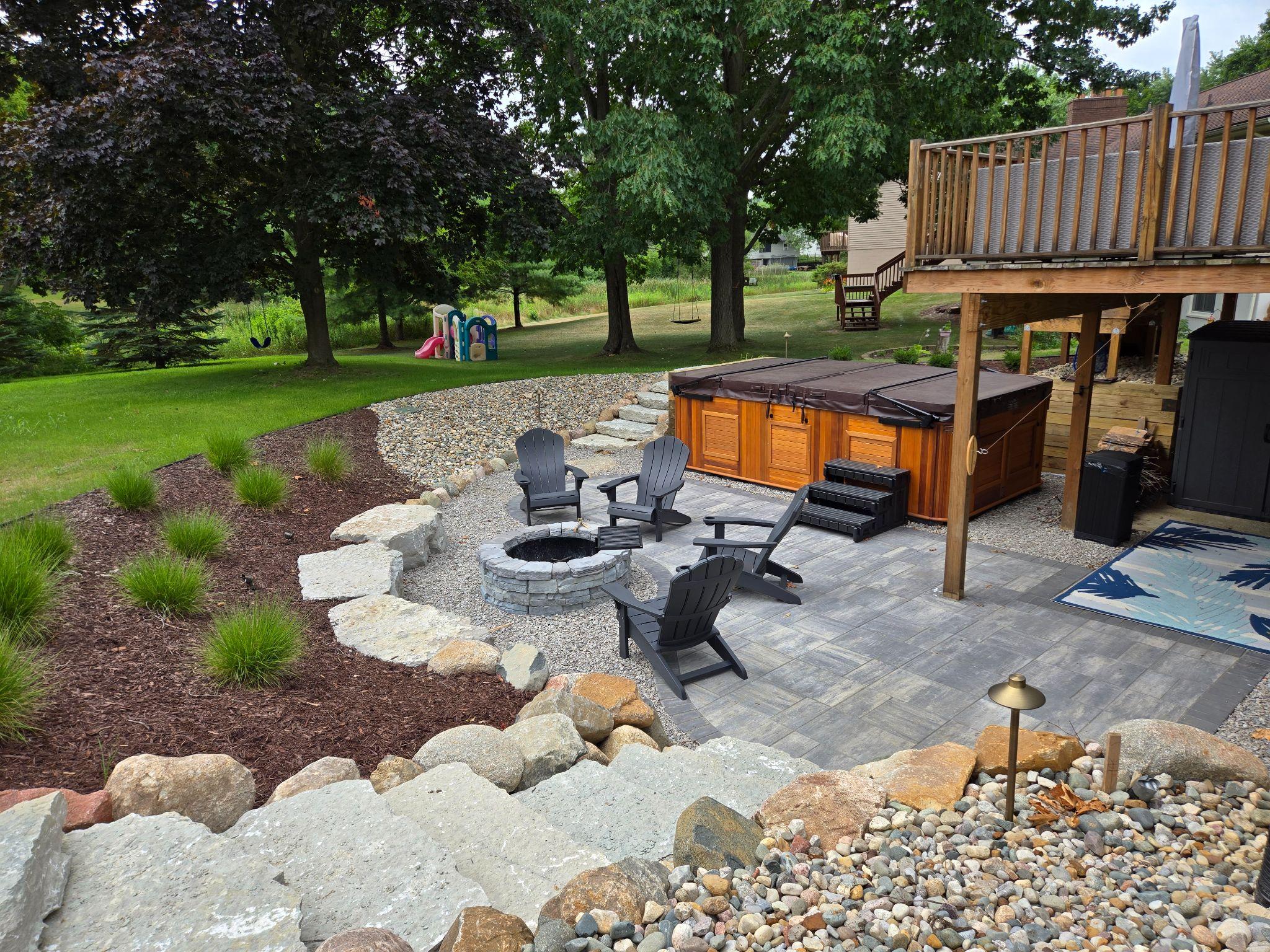 Backyard patio with fire pit, seating, and hot tub area