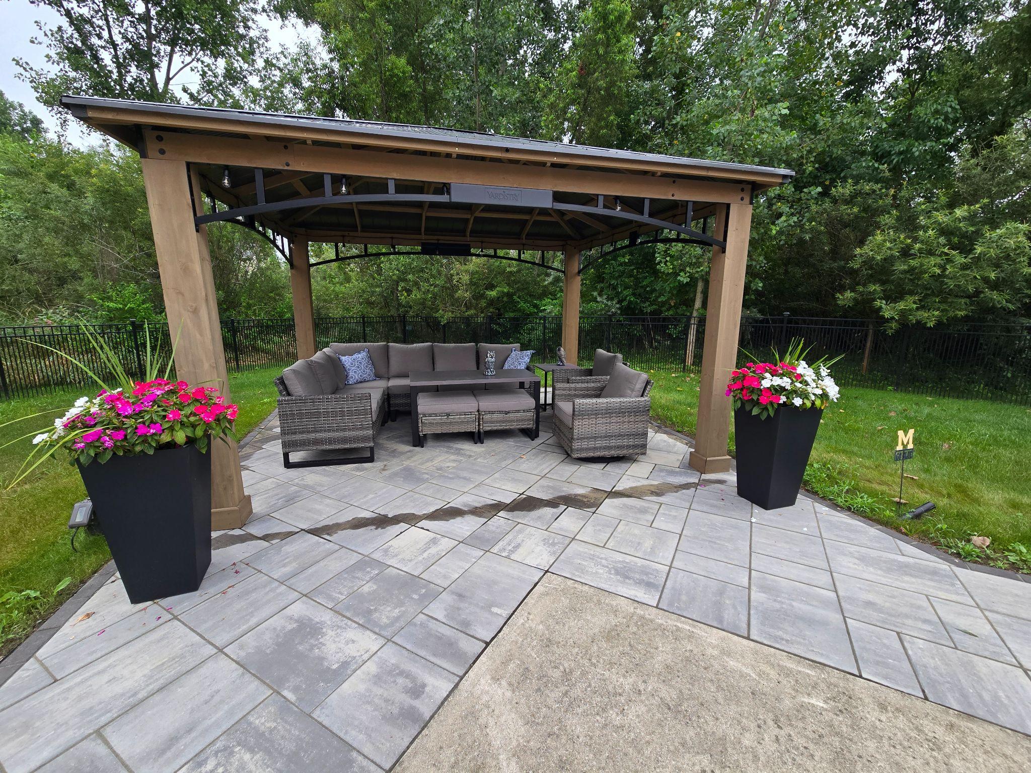 Covered patio pergola with outdoor seating and stone paver floor
