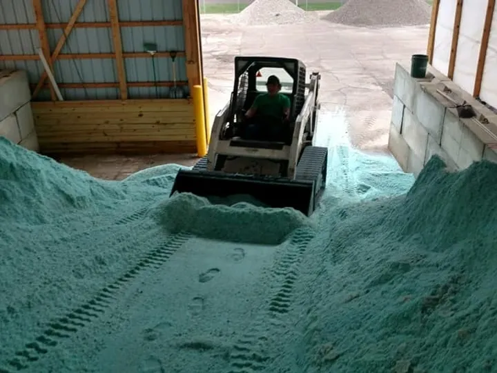 Loader pushing green substance in warehouse