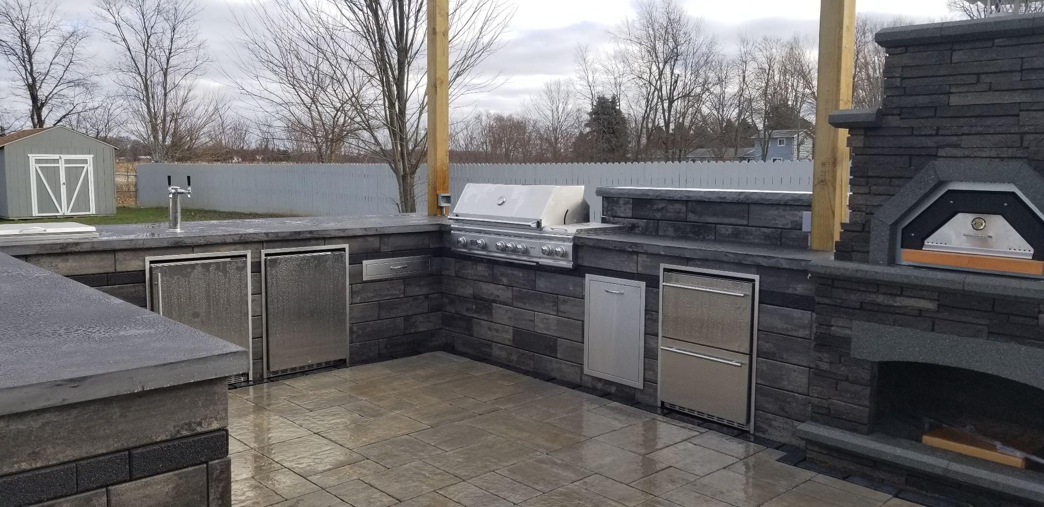 Custom outdoor kitchen with stone finishes and built-in grill