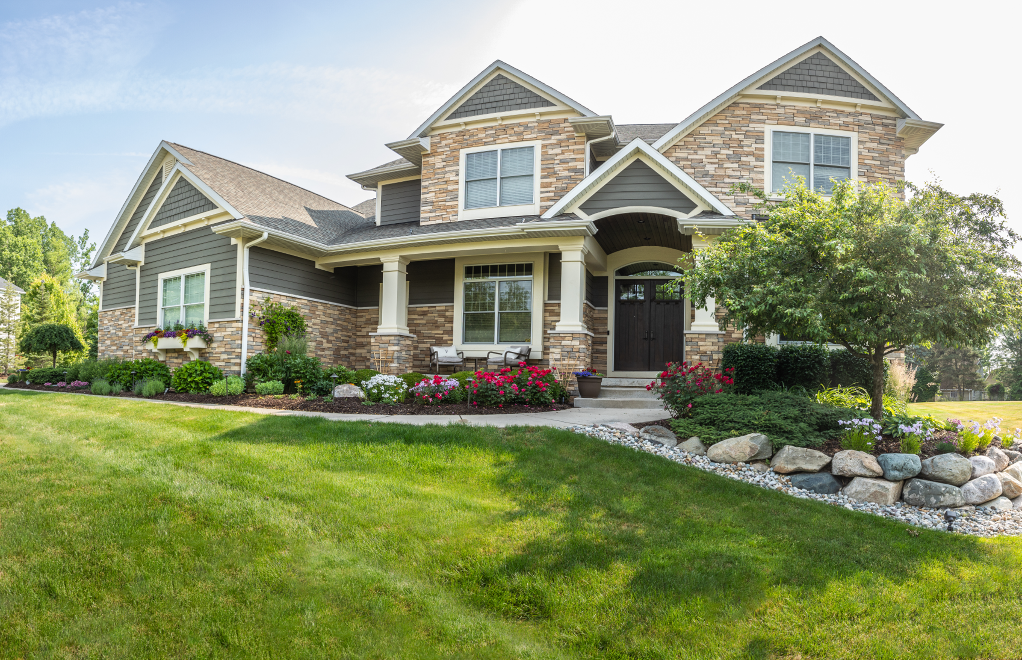 Front yard landscape with stone veneer home and layered plantings