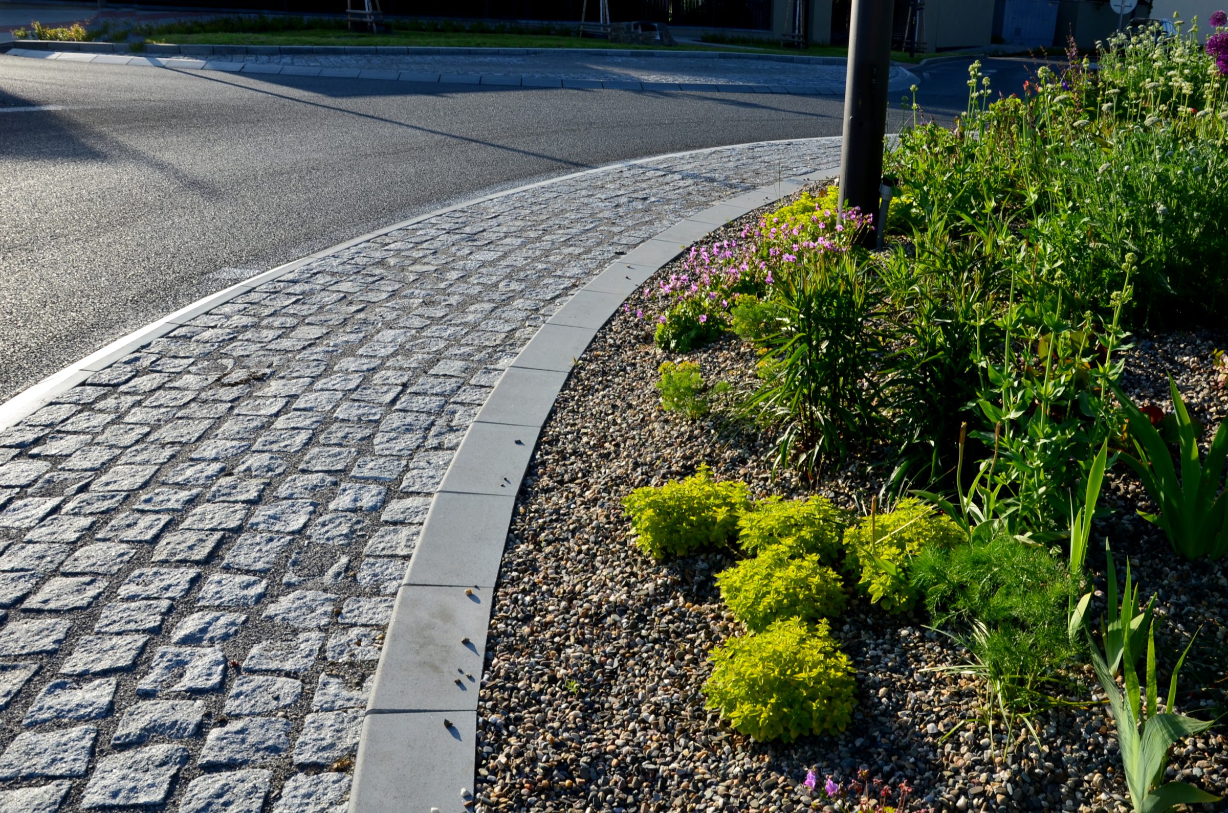 Curved cobblestone path with colorful garden border
