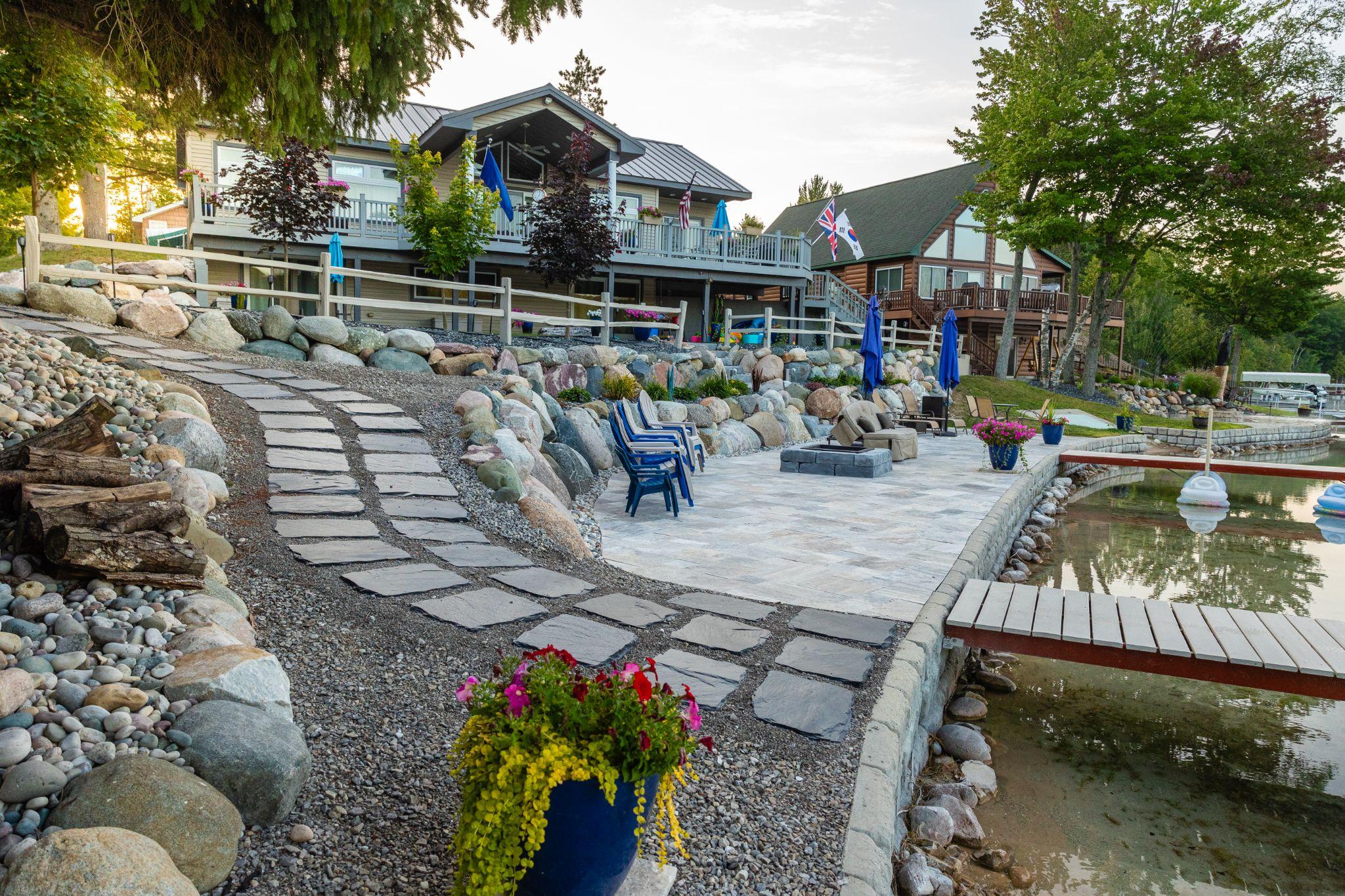 Lakeside patio with stone walkway, retaining walls, and seating area