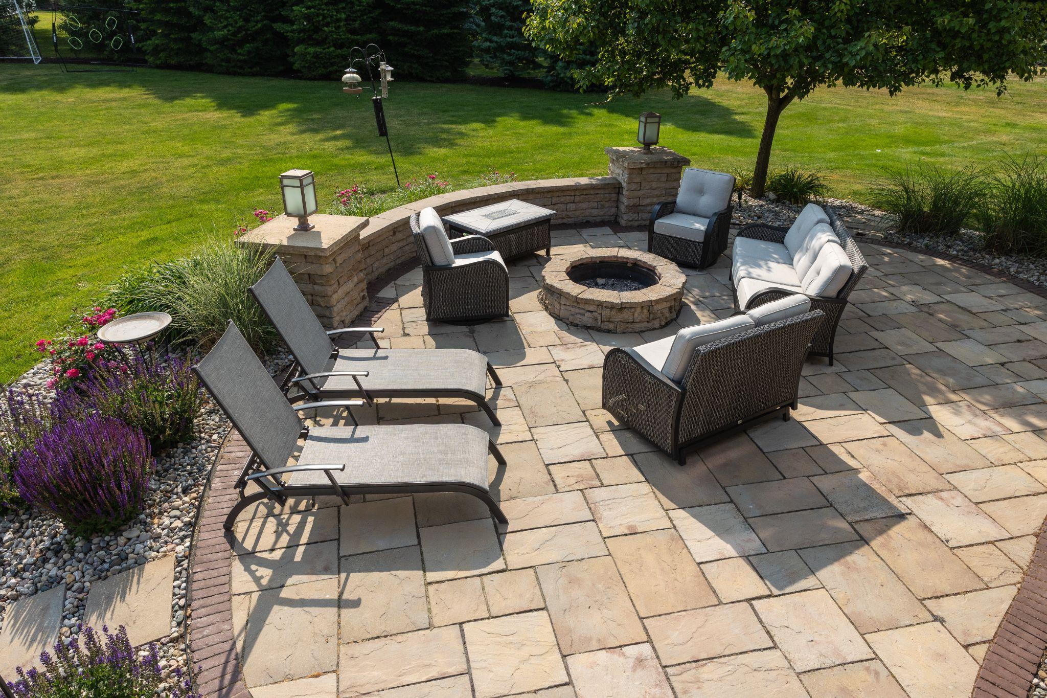 Paver patio with fire pit, seating, and curved retaining wall
